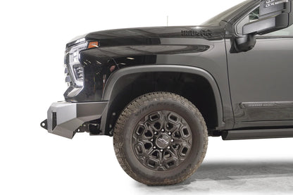 Fab Fours Premium Winch front bumper on a dark gray Chevrolet Silverado 2500HD, side close-up of the front corner, showing the bumper end wing, shackle mount and wheel clearance