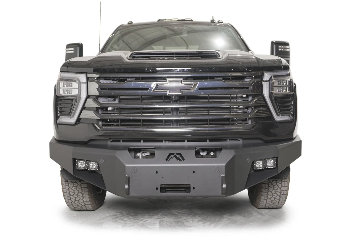 Fab Fours Premium Winch front bumper on a dark gray Chevrolet Silverado 2500HD, straight-on front view, showing the no-guard design, center winch fairlead opening and pod light cutouts