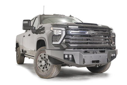 Fab Fours Premium Winch front bumper on a dark gray Chevrolet Silverado 2500HD, front passenger-side three-quarter view, showing the no-guard design, pod light cutouts and winch fairlead opening