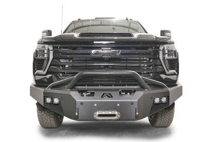 Fab Fours Premium Winch front bumper with pre-runner guard on a black Chevrolet Silverado 2500HD, straight-on front view, showing the pre-runner hoop, center winch fairlead and pod light cutouts