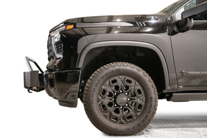 Fab Fours Winch Mount with pre-runner guard on a black Chevrolet Silverado 2500HD, side close-up of the front end, showing the mount's profile, pre-runner tube and factory bumper integration