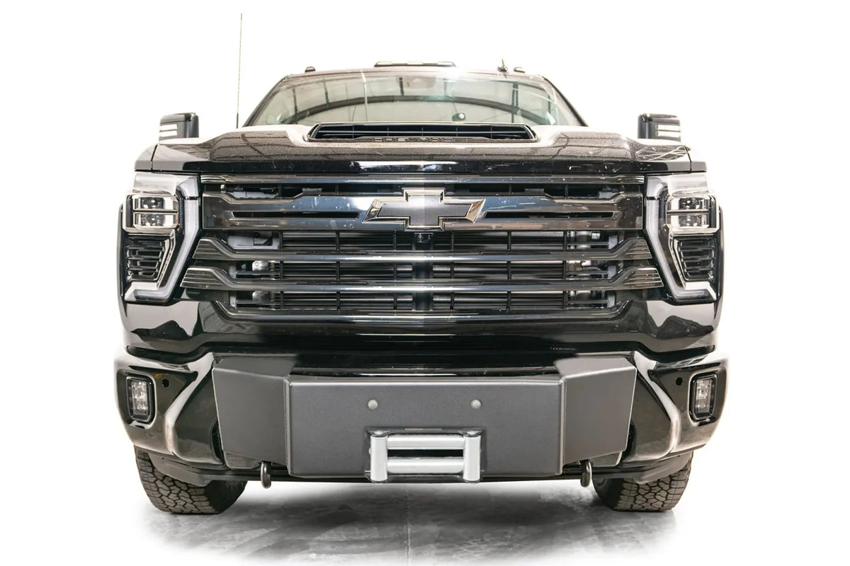 Fab Fours Winch Mount on a black Chevrolet Silverado 2500HD, straight-on front view, showing the no-guard winch mount face, roller fairlead and factory bumper integration