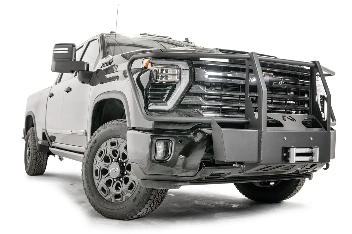 Fab Fours Winch Mount with full guard on a black Chevrolet Silverado 2500HD, front passenger-side three-quarter view, showing the tubular guard uprights, winch plate and roller fairlead