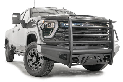 Fab Fours Black Steel Elite front bumper with full guard on a black Chevrolet Silverado 2500HD, front passenger-side three-quarter view, showing the tubular guard, mesh side vent and slotted skid plate