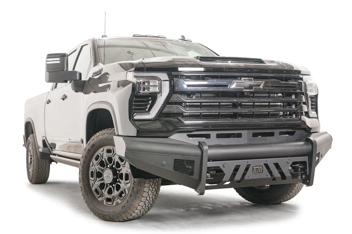 Fab Fours Black Steel Elite front bumper on a black Chevrolet Silverado 2500HD, front passenger-side three-quarter view, showing the no-guard design, mesh side vent and slotted skid plate