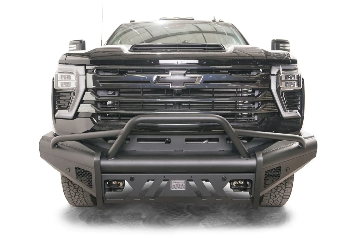 Fab Fours Black Steel Elite front bumper with pre-runner guard on a black Chevrolet Silverado 2500HD, straight-on front view, showing the tubular pre-runner hoop, slotted center skid plate and pod light openings