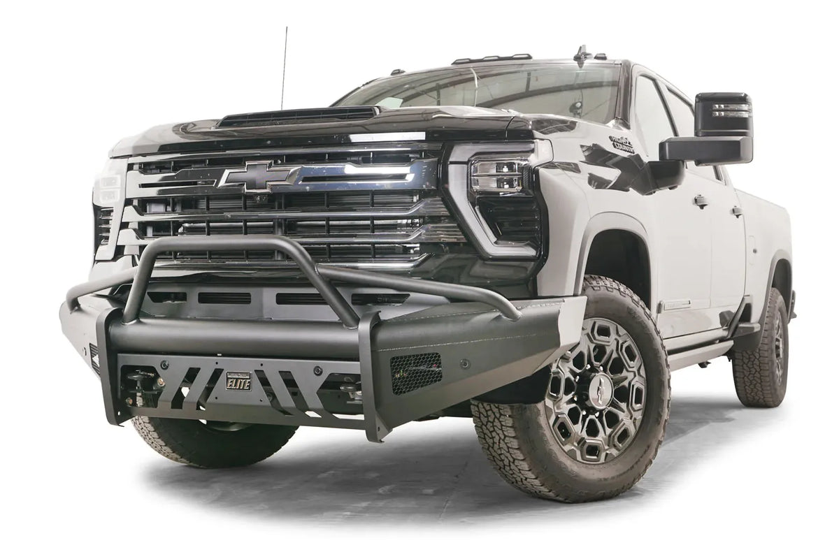 Fab Fours Black Steel Elite front bumper with pre-runner guard on a black Chevrolet Silverado 2500HD, front driver-side three-quarter view, showing the tubular pre-runner hoop, slotted skid plate and mesh side vents