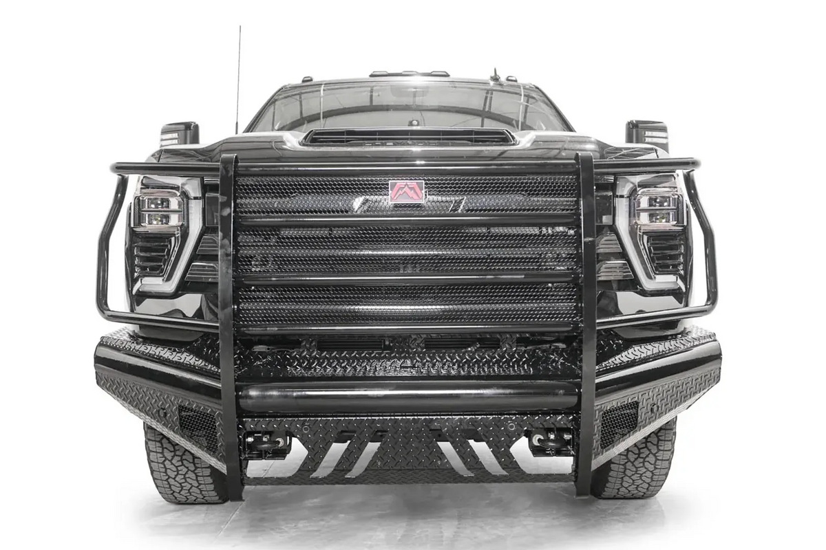Fab Fours Black Steel front bumper with full guard on a black Chevrolet Silverado 2500HD, straight-on front view, showing the full-width mesh grille guard, red logo plate and diamond-plate skid plate