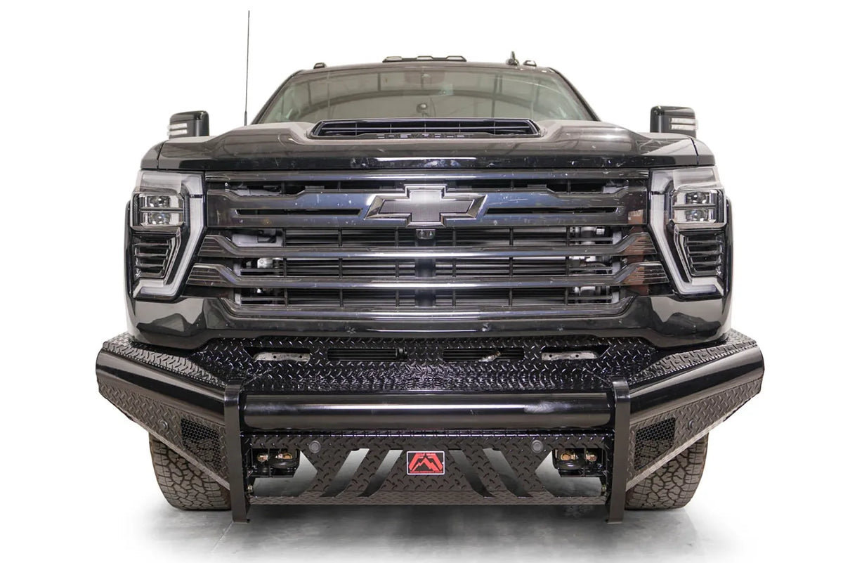 Fab Fours Black Steel front bumper on a black Chevrolet Silverado 2500HD, straight-on front view, showing the diamond-plate bumper face, slotted skid plate and red logo plate