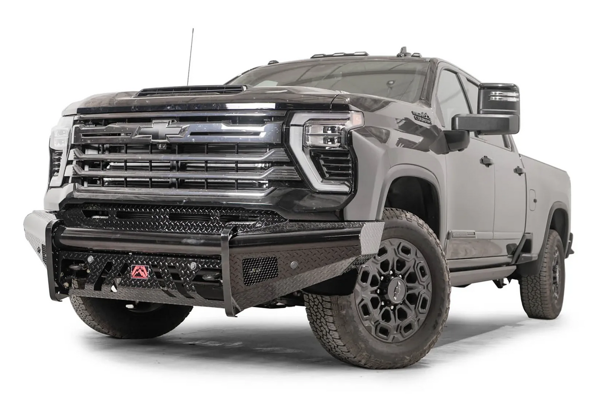 Fab Fours Black Steel front bumper on a black Chevrolet Silverado 2500HD, front driver-side three-quarter view, showing the no-guard design, diamond-plate face and red logo plate