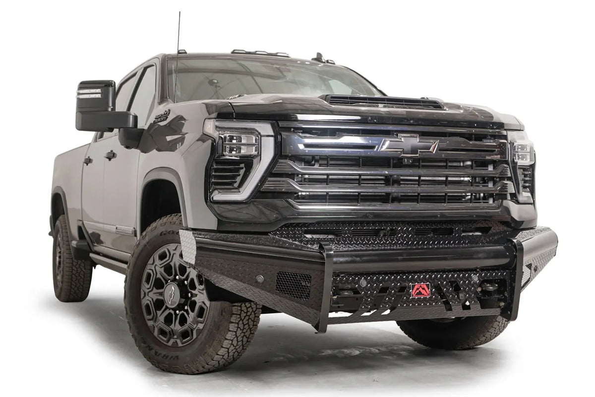 Fab Fours Black Steel front bumper on a black Chevrolet Silverado 2500HD, front passenger-side three-quarter view, showing the no-guard design, diamond-plate end wing and mesh vents