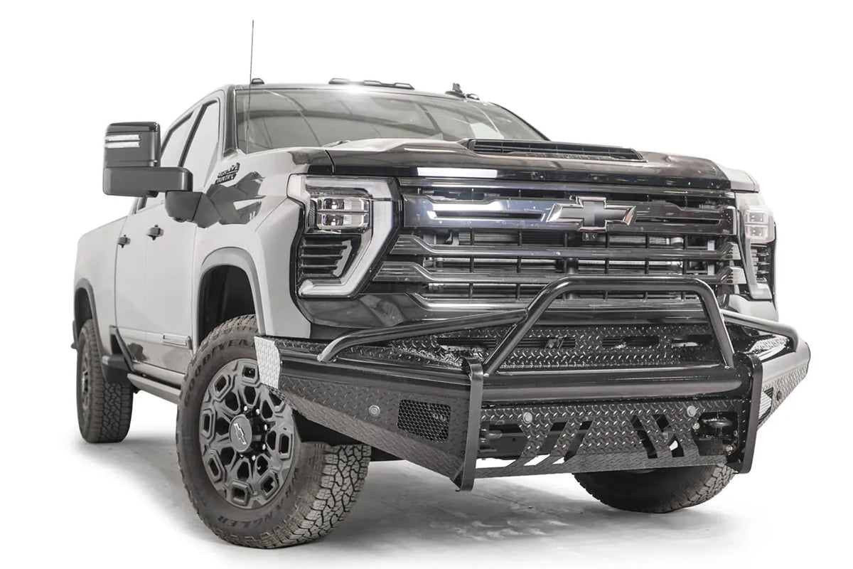 Fab Fours Black Steel front bumper with pre-runner guard on a black Chevrolet Silverado 2500HD, front passenger-side three-quarter view, showing the pre-runner hoop, diamond-plate end wing and mesh vents