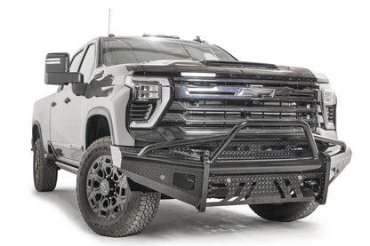 Fab Fours Black Steel front bumper with pre-runner guard on a black Chevrolet Silverado 2500HD, front passenger-side three-quarter view, showing the pre-runner hoop, diamond-plate end wing and mesh vents