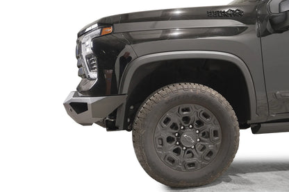 Fab Fours Vengeance front bumper on a black Chevrolet Silverado 2500HD, side close-up of the front corner, showing the angular bumper end wing and wheel clearance