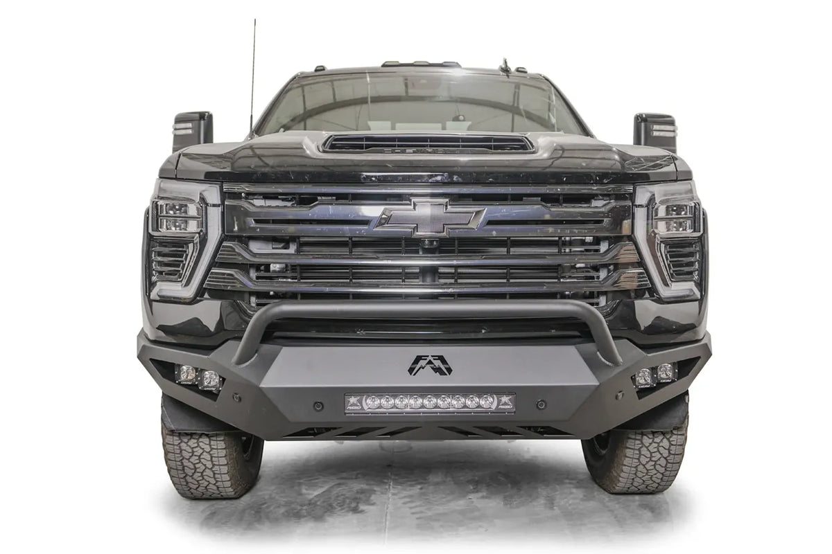 Fab Fours Vengeance front bumper with pre-runner guard on a dark gray Chevrolet Silverado 2500HD, straight-on front view, showing the pre-runner hoop, center light bar and pod light openings