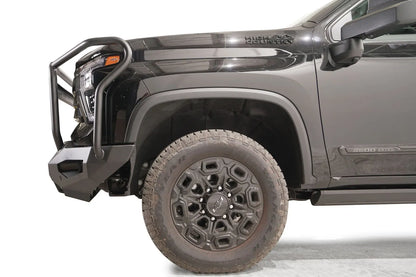 Fab Fours Matrix front bumper with full guard on a black Chevrolet Silverado 2500HD, side close-up of the front corner, showing the guard hoop profile, bumper end wing and wheel clearance