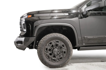 Fab Fours Matrix front bumper on a black Chevrolet Silverado 2500HD, side close-up of the front corner, showing the bumper end wing profile and wheel clearance