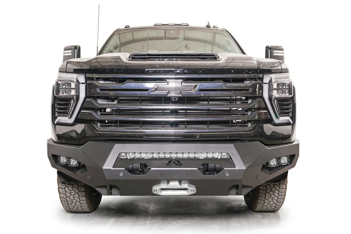Fab Fours Matrix front bumper on a black Chevrolet Silverado 2500HD, straight-on front view, showing the center light bar, winch fairlead and pod light openings