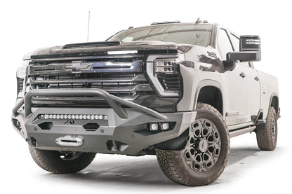 Fab Fours Matrix front bumper with pre-runner guard on a black Chevrolet Silverado 2500HD, front driver-side three-quarter view, showing the pre-runner hoop, integrated light bar and pod light openings