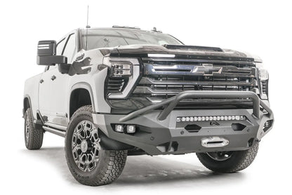Fab Fours Matrix front bumper with pre-runner guard on a black Chevrolet Silverado 2500HD, front passenger-side three-quarter view, showing the tubular pre-runner hoop, integrated light bar and winch fairlead