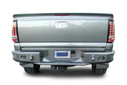 Fab Fours Premium rear bumper on a gray Chevrolet Silverado 2500HD, straight-on rear view, showing the black steel bumper face, logo cutouts, D-ring mounts and center step