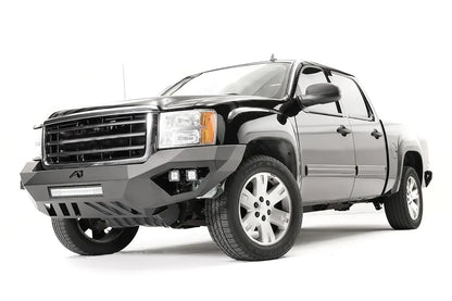 Fab Fours Vengeance front bumper on a black GMC Sierra 1500, front driver-side three-quarter view, showing the no-guard design, integrated light bar and cube light pods