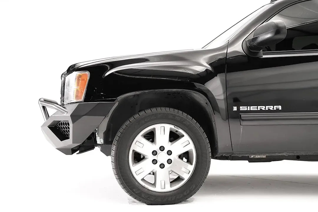 Fab Fours Vengeance front bumper with pre-runner guard on a black GMC Sierra 1500, side close-up of the front corner, showing the pre-runner tube, mesh-vented end wing and wheel clearance