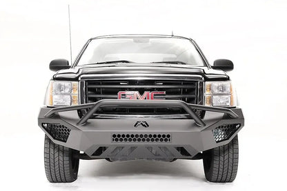 Fab Fours Vengeance front bumper with pre-runner guard on a black GMC Sierra 1500, straight-on front view, showing the tubular pre-runner hoop, honeycomb mesh vents and center light bar cutout