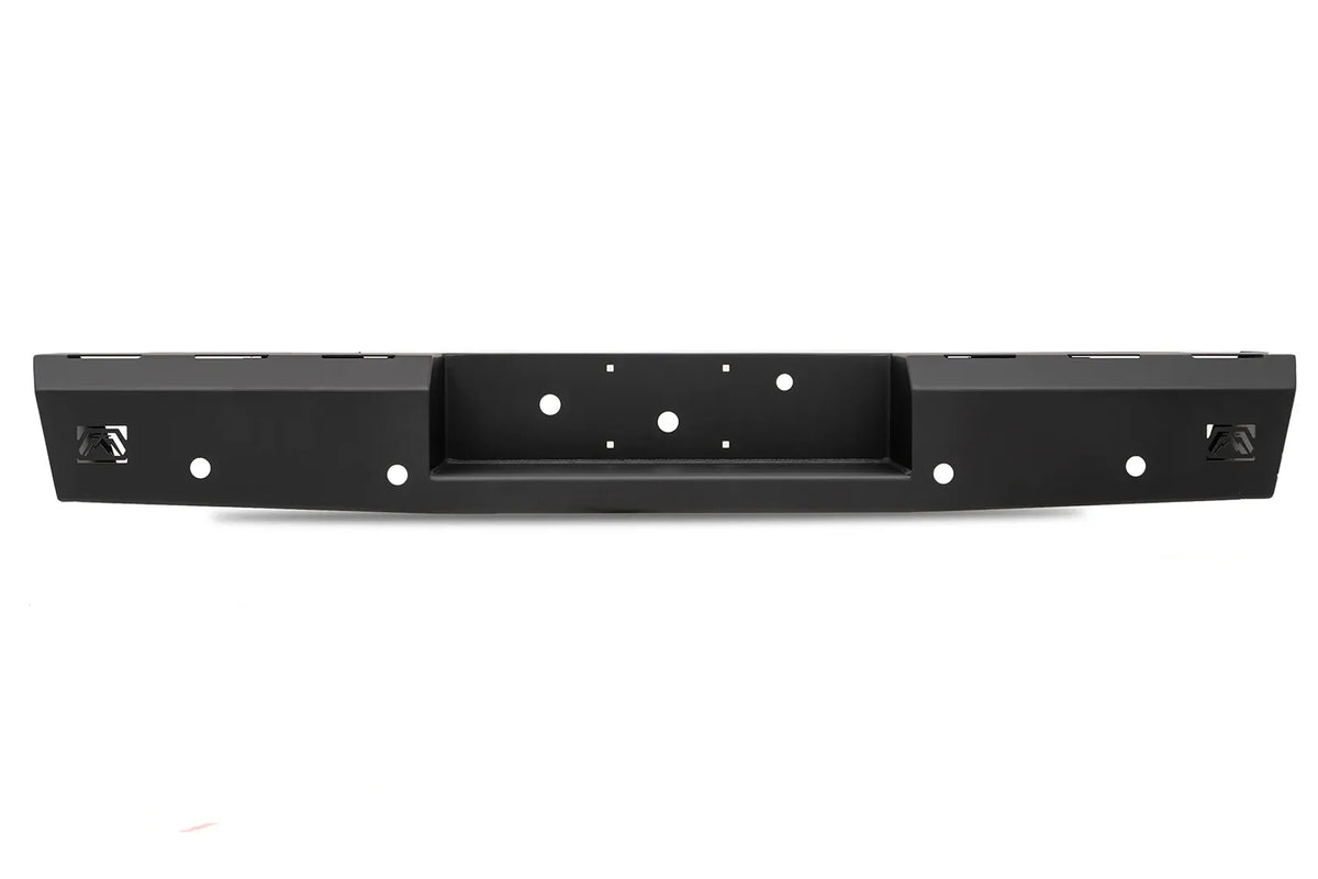 Fab Fours Red Steel rear bumper in black powder coat, straight-on rear view, showing the full-width face, recessed center hitch pocket and logo cutouts