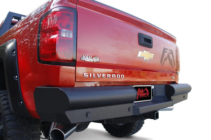 Fab Fours Black Steel Elite Rear Bumper on a red Chevrolet Silverado 1500, rear driver-side view, showing the ranch-style pipe and plate design with sensor holes and center license plate mount