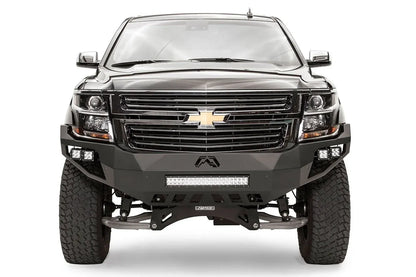 Fab Fours Vengeance front bumper on a black lifted Chevrolet Suburban, straight-on front view, showing the full-width bumper face, center light bar and cube light pods