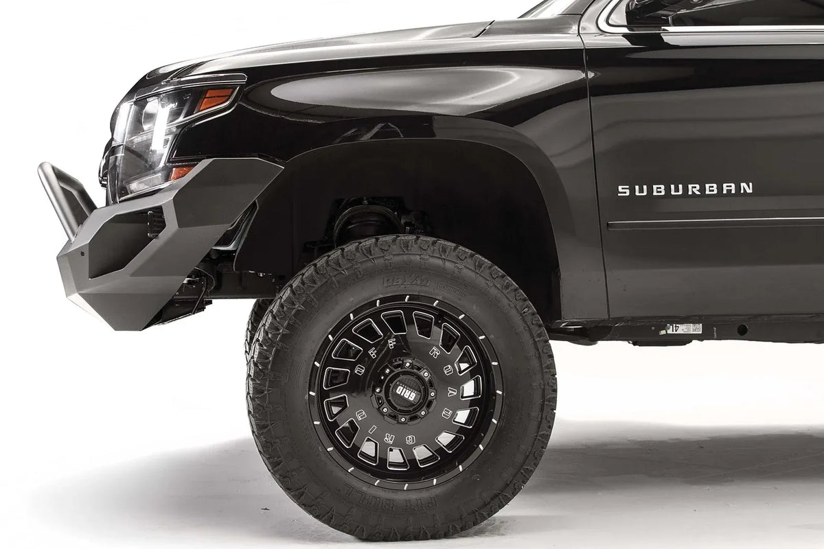 Fab Fours Vengeance front bumper with pre-runner guard on a black lifted Chevrolet Suburban, side close-up of the front corner, showing the pre-runner tube, angular end wing and wheel clearance