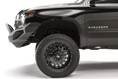 Fab Fours Vengeance front bumper with pre-runner guard on a black lifted Chevrolet Suburban, side close-up of the front corner, showing the pre-runner tube, angular end wing and wheel clearance