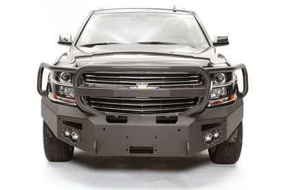 Fab Fours Premium Winch front bumper with full guard on a black Chevrolet Suburban, straight-on front view, showing the tubular full grille guard, winch mount opening and round light cutouts