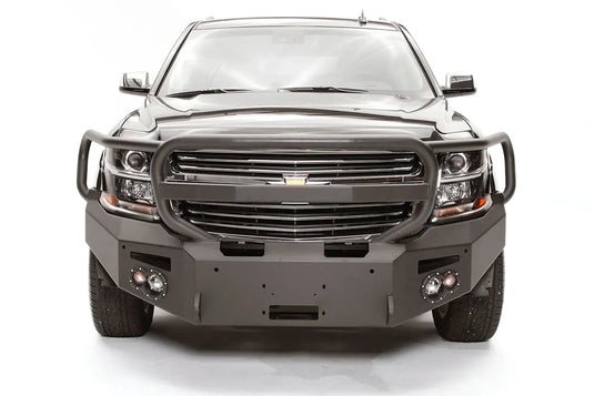 Fab Fours Premium Winch front bumper with full guard on a black Chevrolet Suburban, straight-on front view, showing the tubular full grille guard, winch mount opening and round light cutouts