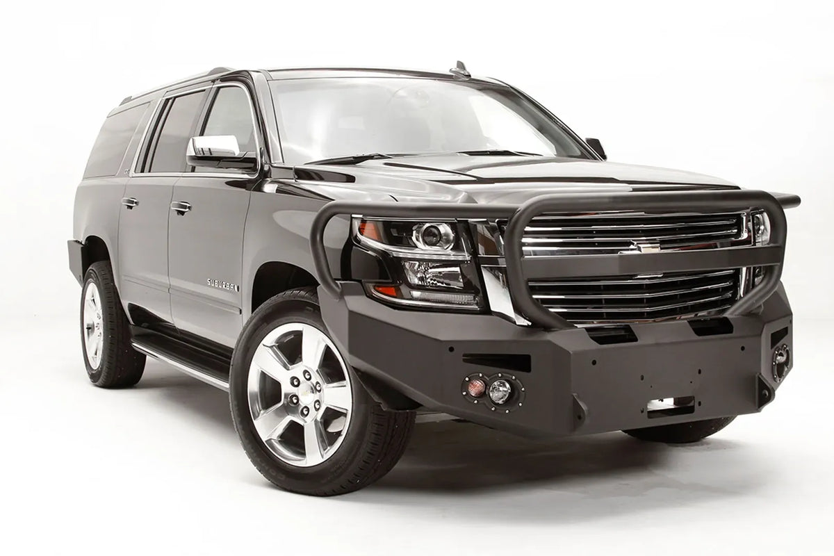 Fab Fours Premium Winch front bumper with full guard on a black Chevrolet Suburban, front passenger-side three-quarter view, showing the tubular guard, winch mount and angled end wing