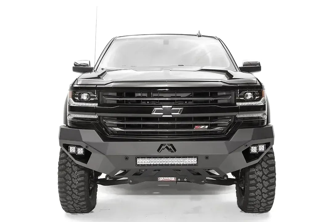 Fab Fours Vengeance front bumper on a black lifted Chevrolet Silverado 1500, straight-on front view, showing the full-width bumper face, center light bar and cube light pods