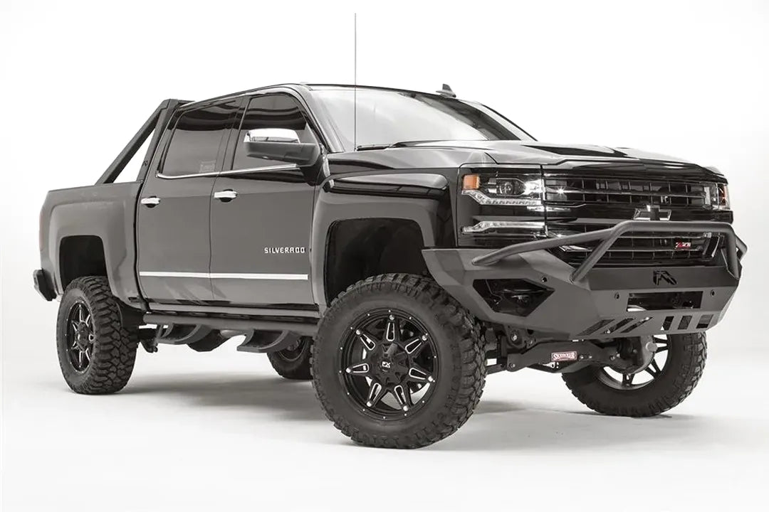 Fab Fours Vengeance front bumper with pre-runner guard on a black lifted Chevrolet Silverado 1500, front passenger-side three-quarter view, showing the pre-runner hoop, angular end wing and logo cutout