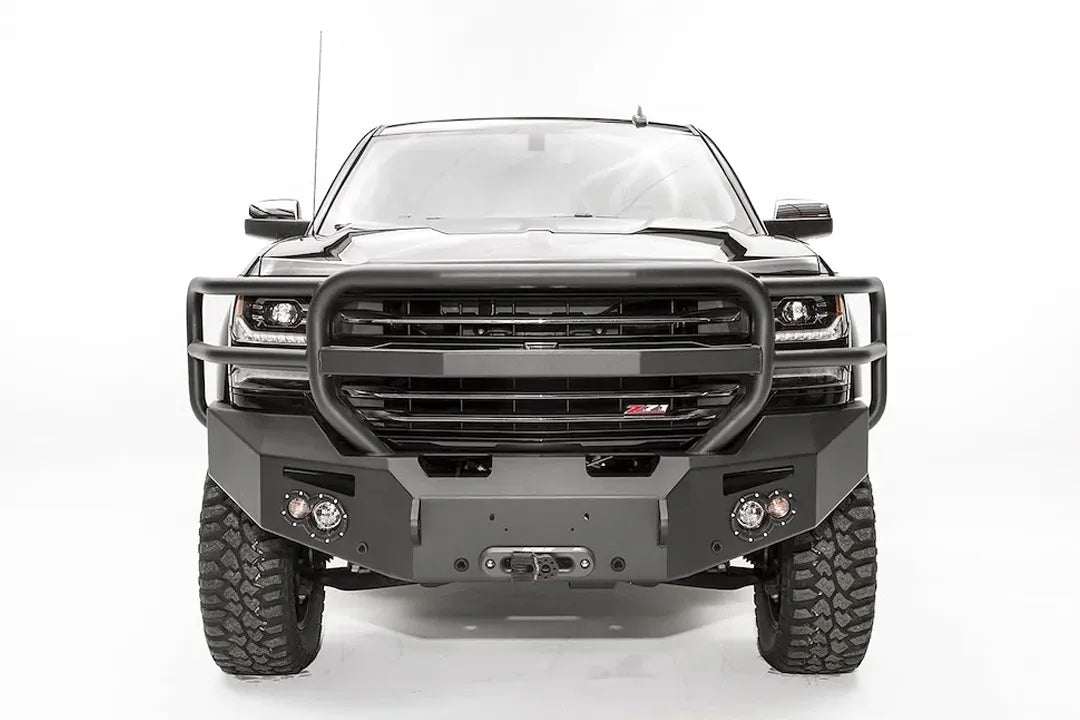Fab Fours Premium front bumper with full guard on a black lifted Chevrolet Silverado 1500, straight-on front view, showing the tubular full grille guard, winch fairlead opening and round light cutouts