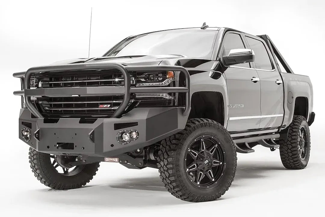 Fab Fours Premium front bumper with full guard on a black lifted Chevrolet Silverado 1500, front driver-side three-quarter view, showing the tubular full grille guard, winch mount and angled end wing
