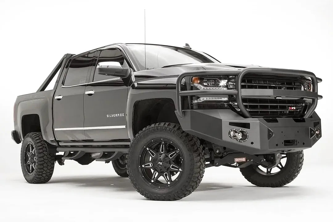 Fab Fours Premium front bumper with full guard on a black lifted Chevrolet Silverado 1500, front passenger-side three-quarter view, showing the tubular full grille guard, winch mount and round light cutouts
