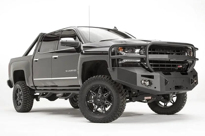 Fab Fours Premium front bumper with full guard on a black lifted Chevrolet Silverado 1500, front passenger-side three-quarter view, showing the tubular full grille guard, winch mount and round light cutouts