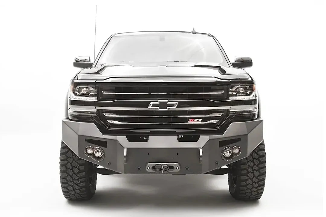 Fab Fours Premium front bumper on a black lifted Chevrolet Silverado 1500, straight-on front view, showing the no-guard design, winch fairlead opening and round light cutouts