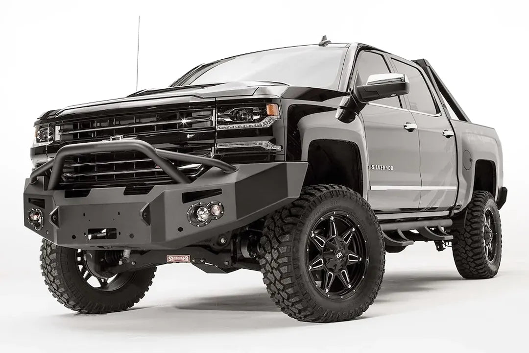 Fab Fours Premium front bumper with pre-runner guard on a black lifted Chevrolet Silverado 1500, front driver-side three-quarter view, showing the tubular pre-runner hoop, winch mount and angled end wing