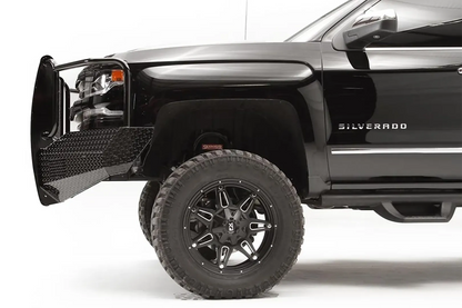 Fab Fours Black Steel front bumper with full guard on a black lifted Chevrolet Silverado 1500, side close-up of the front corner, showing the guard upright, diamond-plate end wing and wheel clearance