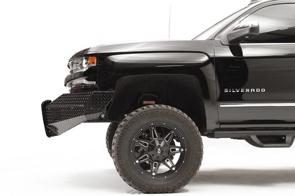 Fab Fours Black Steel front bumper on a black lifted Chevrolet Silverado 1500, side close-up of the front corner, showing the diamond-plate end wing profile and wheel clearance