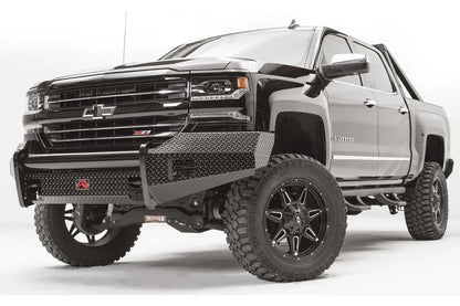 Fab Fours Black Steel front bumper on a black lifted Chevrolet Silverado 1500, front driver-side three-quarter view, showing the no-guard design, diamond-plate wings and red logo plate