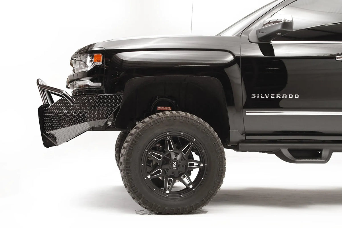 Fab Fours Black Steel front bumper with pre-runner guard on a black Chevrolet Silverado 1500, driver-side profile view, showing the bumper wing depth, pre-runner tubing, and tire clearance