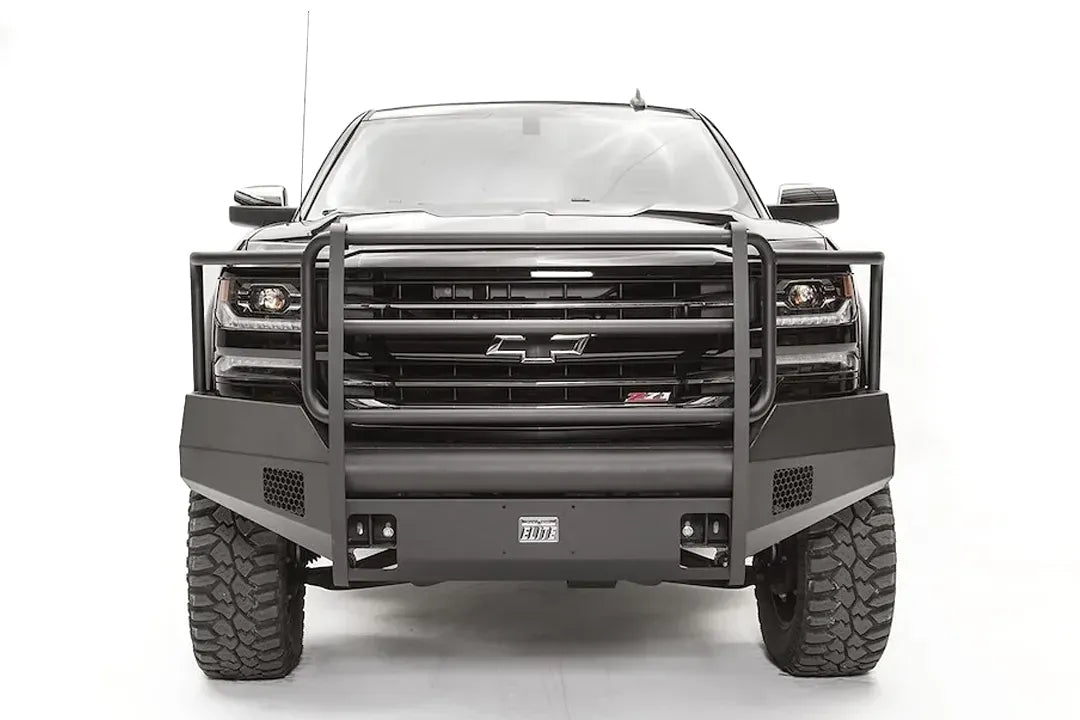 Fab Fours Elite front bumper with full grille guard on a black 2016–2018 Chevrolet Silverado 1500, front view showing the tubular guard, honeycomb side vents, shackle mounts and Elite badge