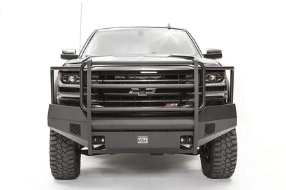 Fab Fours Elite front bumper with full grille guard on a black 2016–2018 Chevrolet Silverado 1500, front view showing the tubular guard, honeycomb side vents, shackle mounts and Elite badge